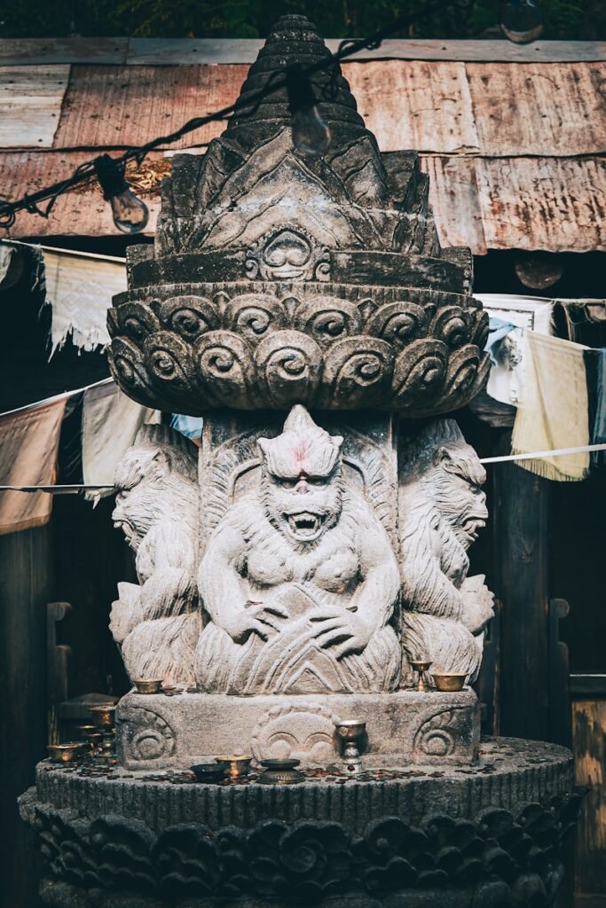 a statue of a person sitting on top of a stone pillar