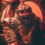 a statue of a monkey sitting in front of a mirror