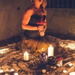 woman in gray tank top holding red smartphone