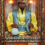 man in yellow and white long sleeve shirt sitting on white ball